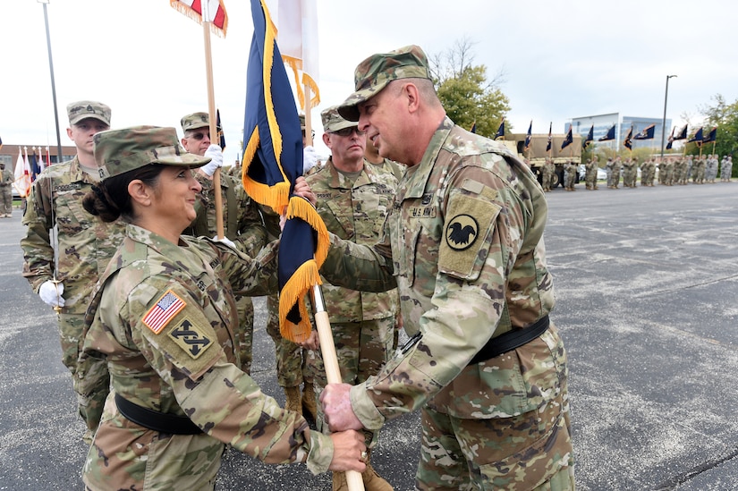 Army Reserve Brig. Gen. Kris A. Belanger, left, Commanding General, 85th Support Command, takes the command Colors from Maj. Gen. Scottie D. Carpenter, Deputy Commanding General, U.S. Army Reserve Command in an Assumption of Command ceremony at the 85th SPT CMD headquarters, October 21, 2017.