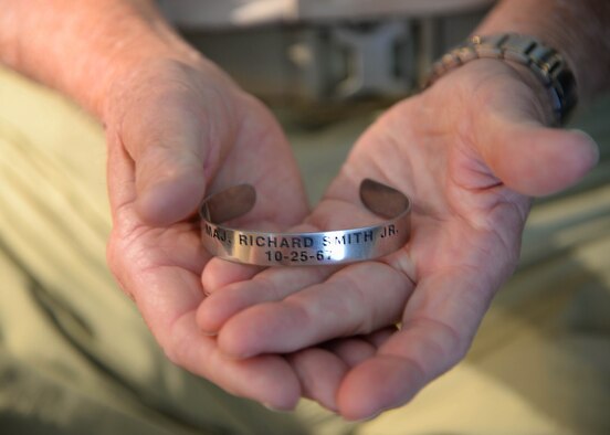 Retired Lt. Col. Richard “Gene” Smith, former 50th Flying Training Squadron Commander, holds a prisoner of war bracelet Oct. 17, 2017. The date Smith was shot down, Oct. 25, 1967, is inscribed on the bracelet, along with his rank and name. The bracelets help keep the memory of POWs and those missing in action. (U.S Air Force photo by Airman 1st Class Beaux Hebert)