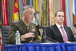 Marine Corps Gen. Joe Dunford speaks at a news conference while seated alongside Brett H. McGurk.