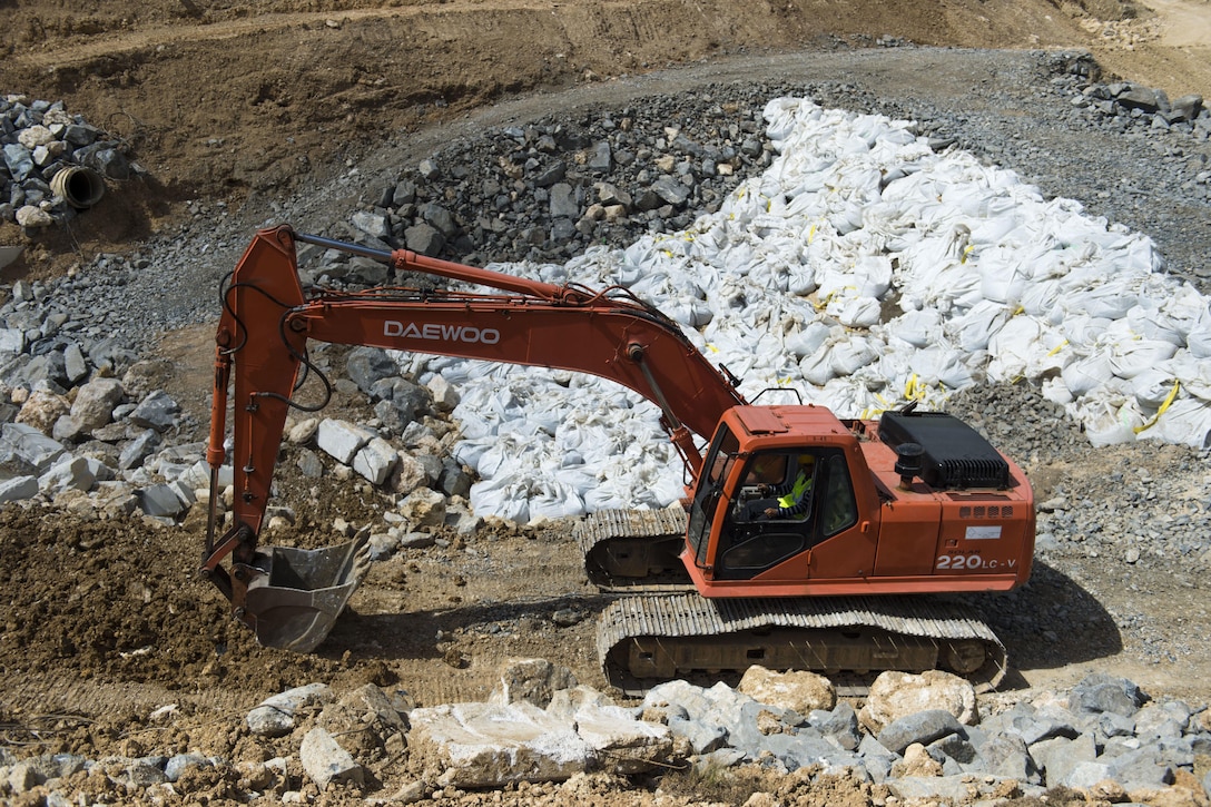 A backhoe digs at Guajataca Dam.