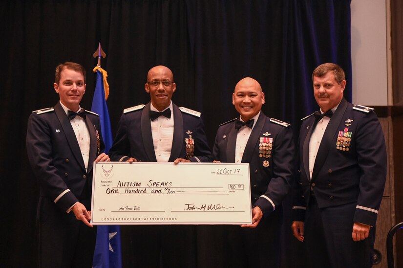 Col. Jeffery Nelson, 628th Air Base Wing commander, far left, Col. Jimmy Canlas, 437th Airlift Wing commander, right and Col. Gregory Gilmour, 315th Airlift Wing commander, far right, present Lt. Gen. Charles Brown, U.S. Central Command deputy commander, a donation to the charity of his choice at the Air Force Ball in the Charleston Area Convention Center in North Charleston, S.C., Oct. 21, 2017.