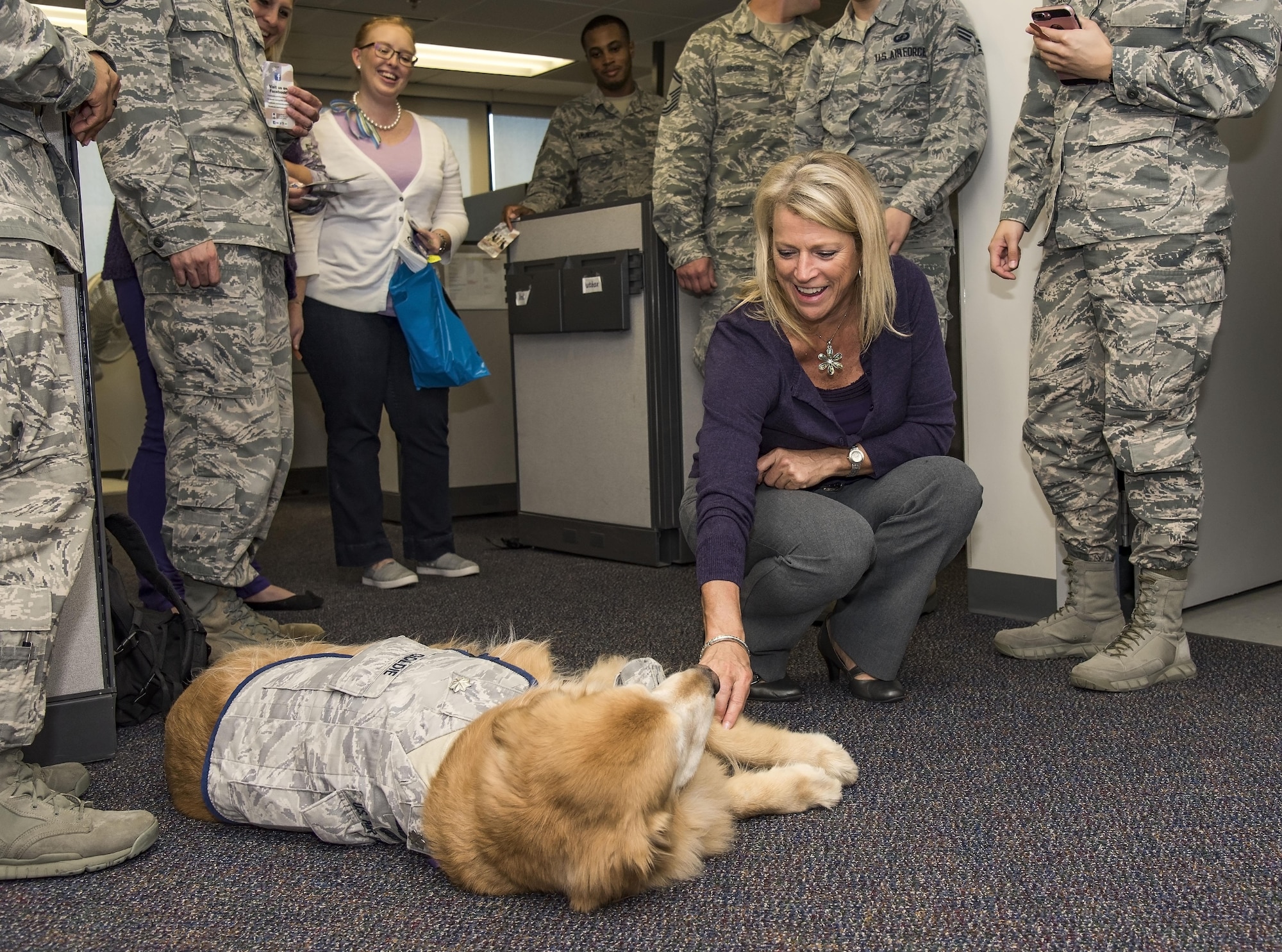 Laura Miller, 436th Comptroller Squadron financial analysis officer, pets Lt. Col. Goldie as he visits Team Dover personnel during Domestic Violence Awareness Month, Oct.19, 2017, on Dover Air Force Base, Del. Goldie is a nine-year-old Golden Retriever therapy dog stationed at Walter Reed National Military Medical Center, Bethesda, Md. (U.S. Air Force photo by Roland Balik)