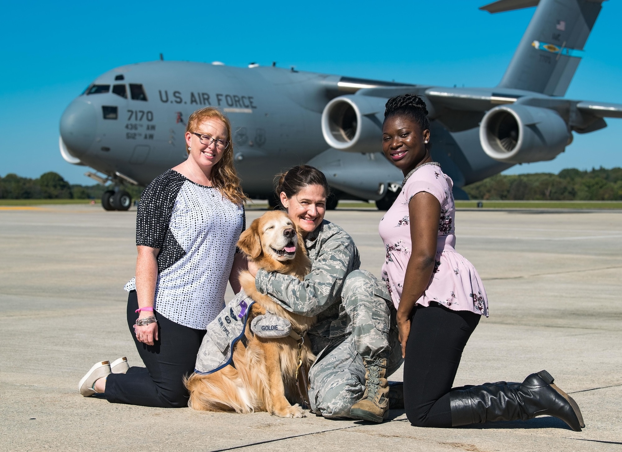 Jennifer Houseman, 436th Medical Operations Squadron Family Advocacy program assistant; Lt. Col. Goldie; Maj. Regina Owen, 436th MDOS psychiatric mental health nurse practitioner; and Ruth Yeboah, 436th MDOS domestic abuse victim advocate, pose for a photo on the flight line in front of a C-17 Globemaster III, Oct. 20, 2017, on Dover Air Force Base, Del. Goldie, the only U.S. Air Force therapy dog, is stationed at Walter Reed National Military Medical Center, Bethesda, Md., took part in the 436th MDOS Family Advocacy Domestic Violence Awareness Month outreach by visiting Team Dover personnel. (U.S. Air Force photo by Roland Balik)