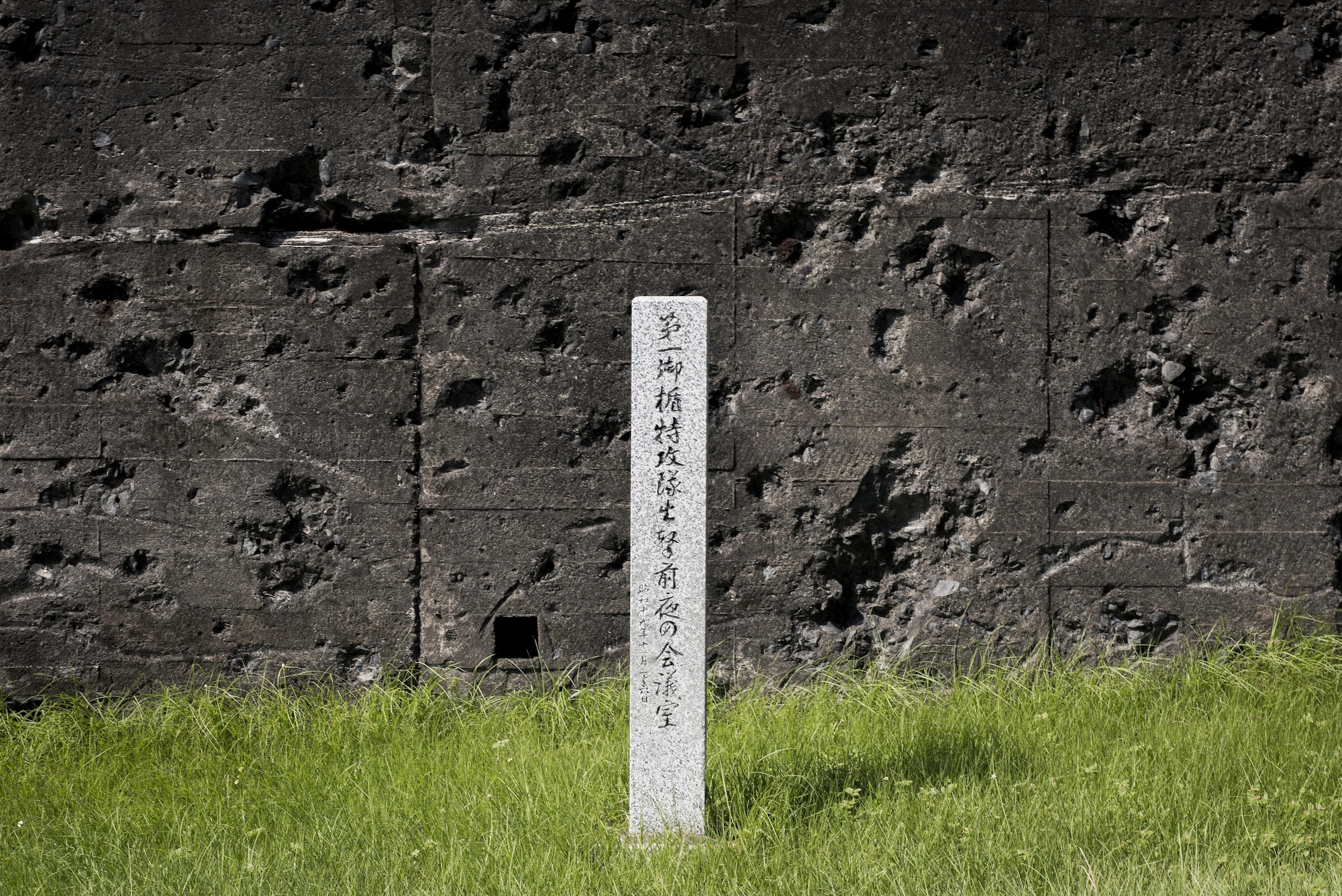A Japanese memorial stands in front of an old concert bunker riddled with bullet holes, Oct. 17, 2017, at Iwo To, Japan.