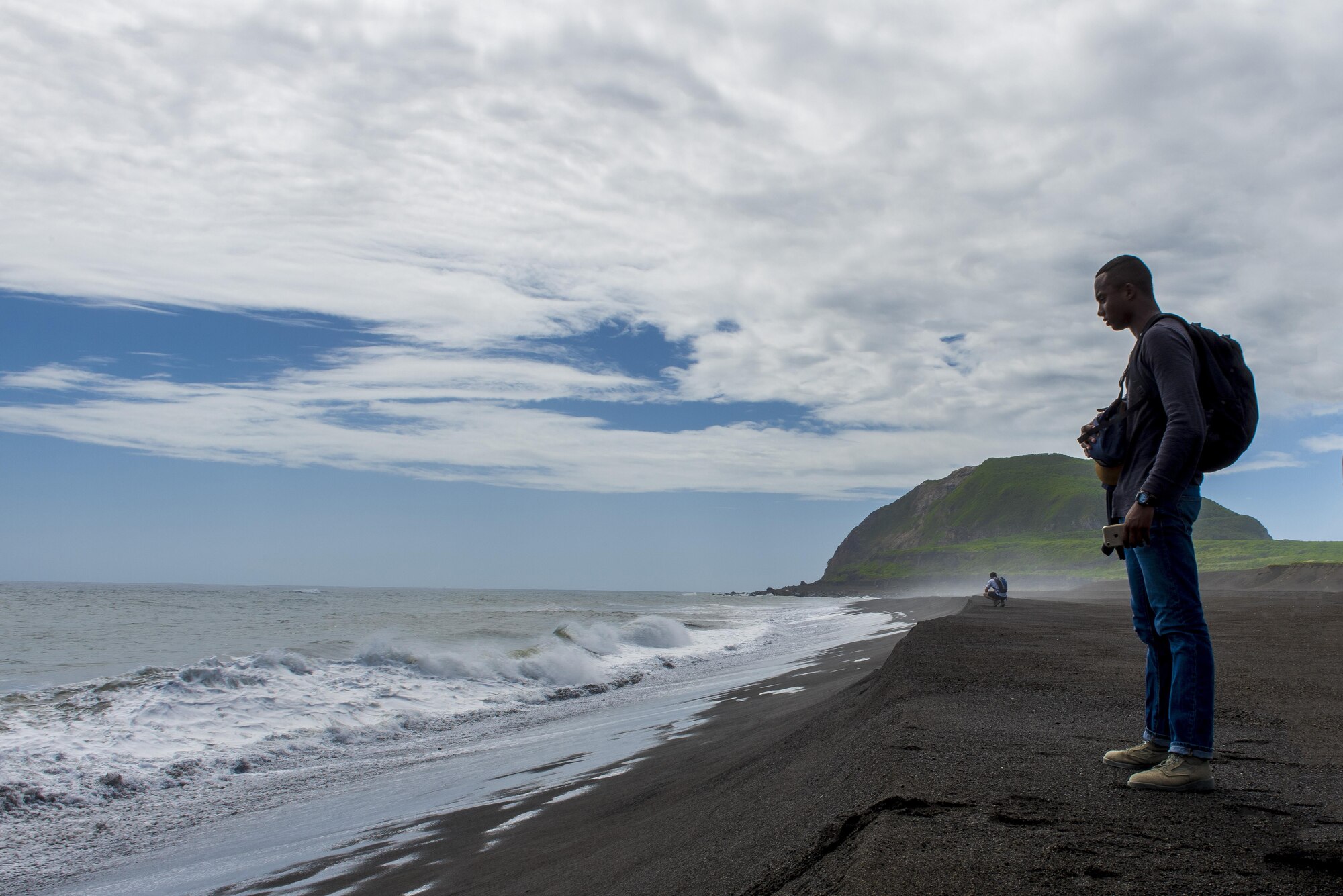 Members of Team Yokota look out over the beach with Mt. Suribachi behind them, Oct. 17, 2017, at Iwo To, Japan.