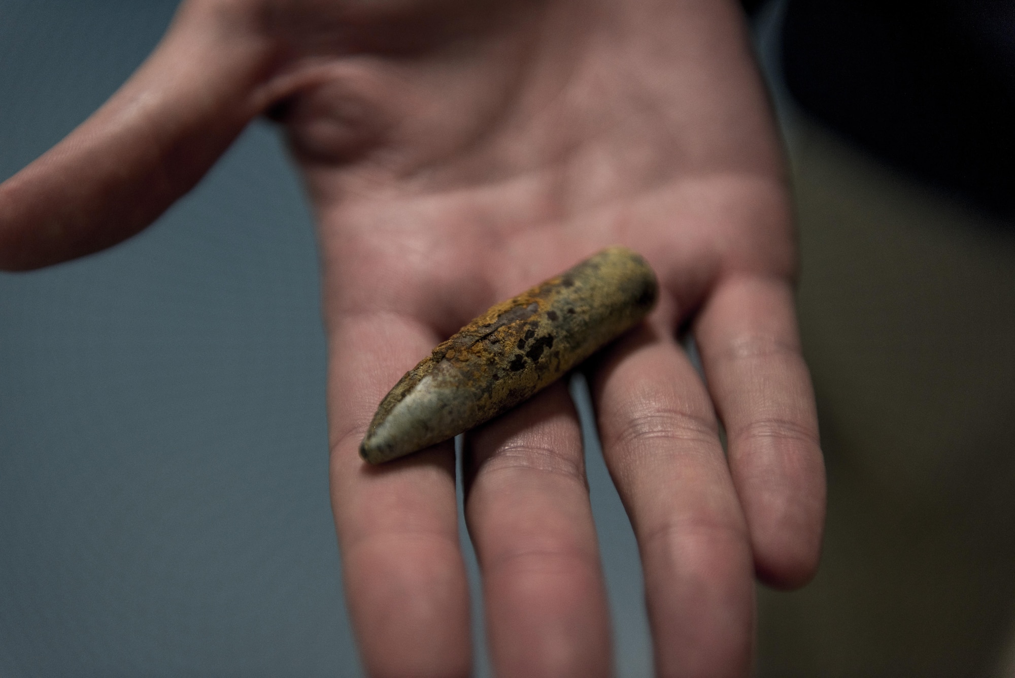 A member of Team Yokota holds a rusted bullet they found in the sand, Oct. 17, 2017, at Iwo To, Japan.