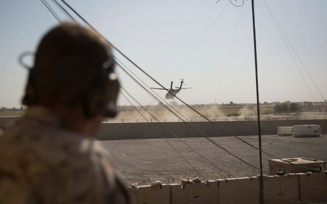 A U.S. Marine advisor and joint-terminal attack controller with Task Force Southwest listens in as a UH-60 Blackhawk departs after a key leader engagement at Bost Airfield, Afghanistan, Oct. 21, 2017. Task Force and Helmand-based Afghan National Defense and Security Force leadership collaborated to discuss courses of action for the second phase of Operation Maiwand Seven. Multiple elements of ANDSF, including the Afghan National Army 215th Corps, 505th Zone National Police and National Directorate of Security among others are working in conjunction to clear the Nad’Ali district of Taliban insurgents. (U.S. Marine Corps photo by Sgt. Justin T. Updegraff)