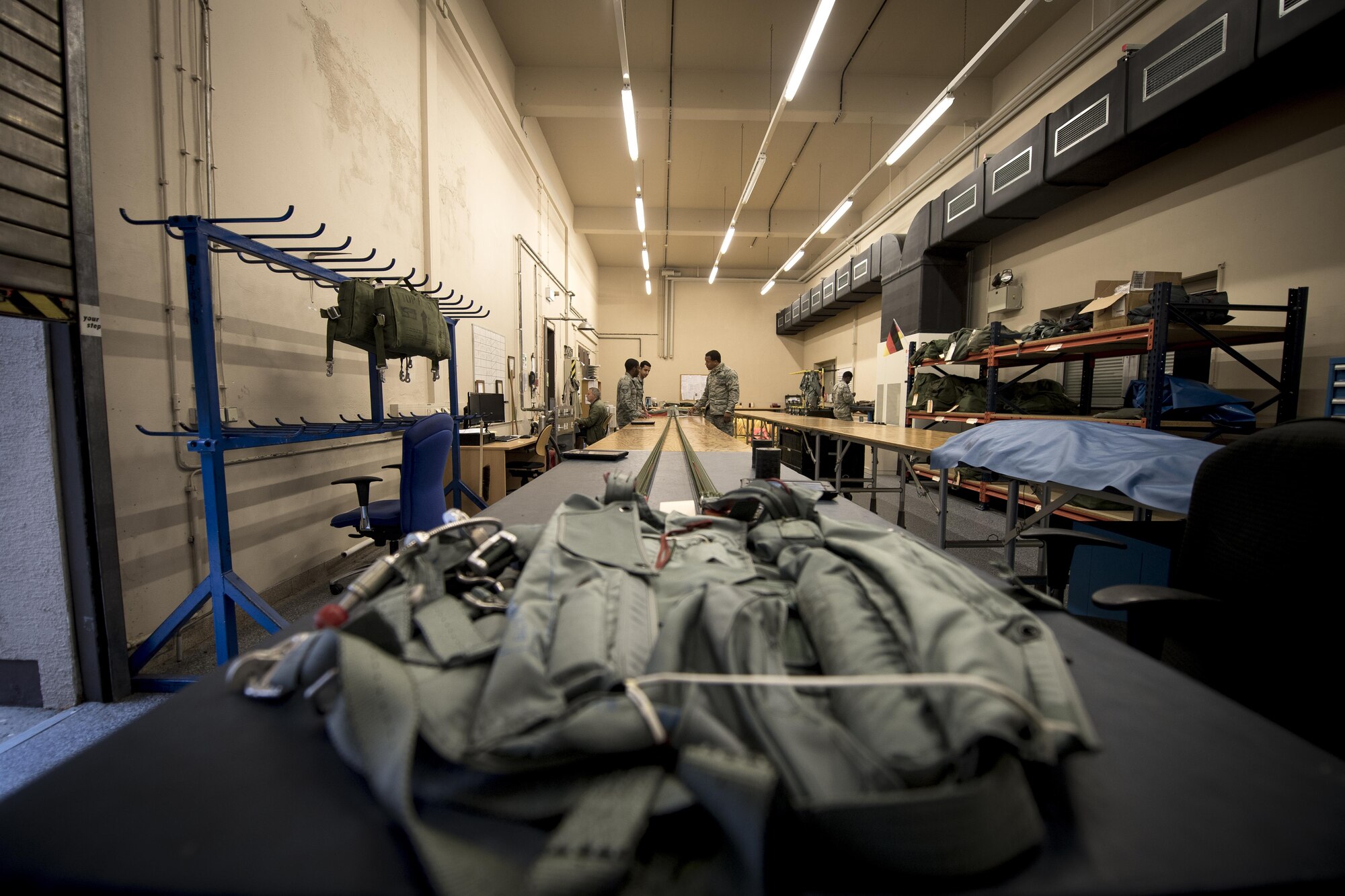 U.S. Air Force Airmen assigned to the 86th Operations Support Squadron Aircrew Flight Equipment prepare to pack a personnel parachute on Ramstein Air Base, Germany, Oct. 24, 2017. Due to the thorough process, it can take hours to pack a single parachute. Aircrew Flight Equipment uses their space to pack two parachutes at a time.  (U.S. Air Force photo by Senior Airman Devin Boyer)