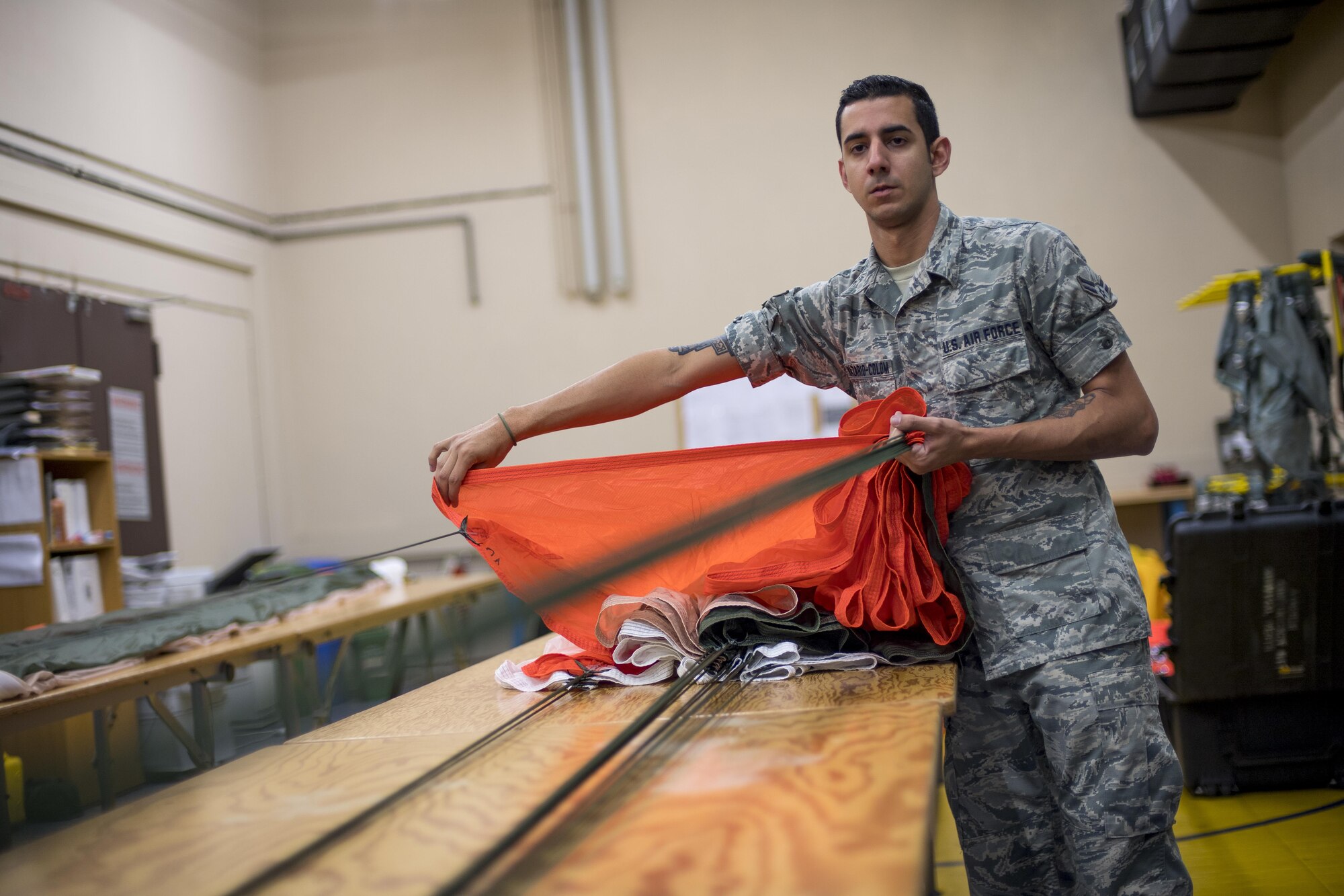 U.S. Air Force Airman 1st Class Ricardo Nazario-Colom, 86th Operations Support Squadron Aircrew Flight Equipment technician, prepares a personnel parachute for packing on Ramstein Air Base, Germany, Oct. 24, 2017. Folding the parachute before packing is a critical step to ensure the parachute deploys quickly. If not done correctly, the parachute may not open at all. (U.S. Air Force photo by Senior Airman Devin Boyer)