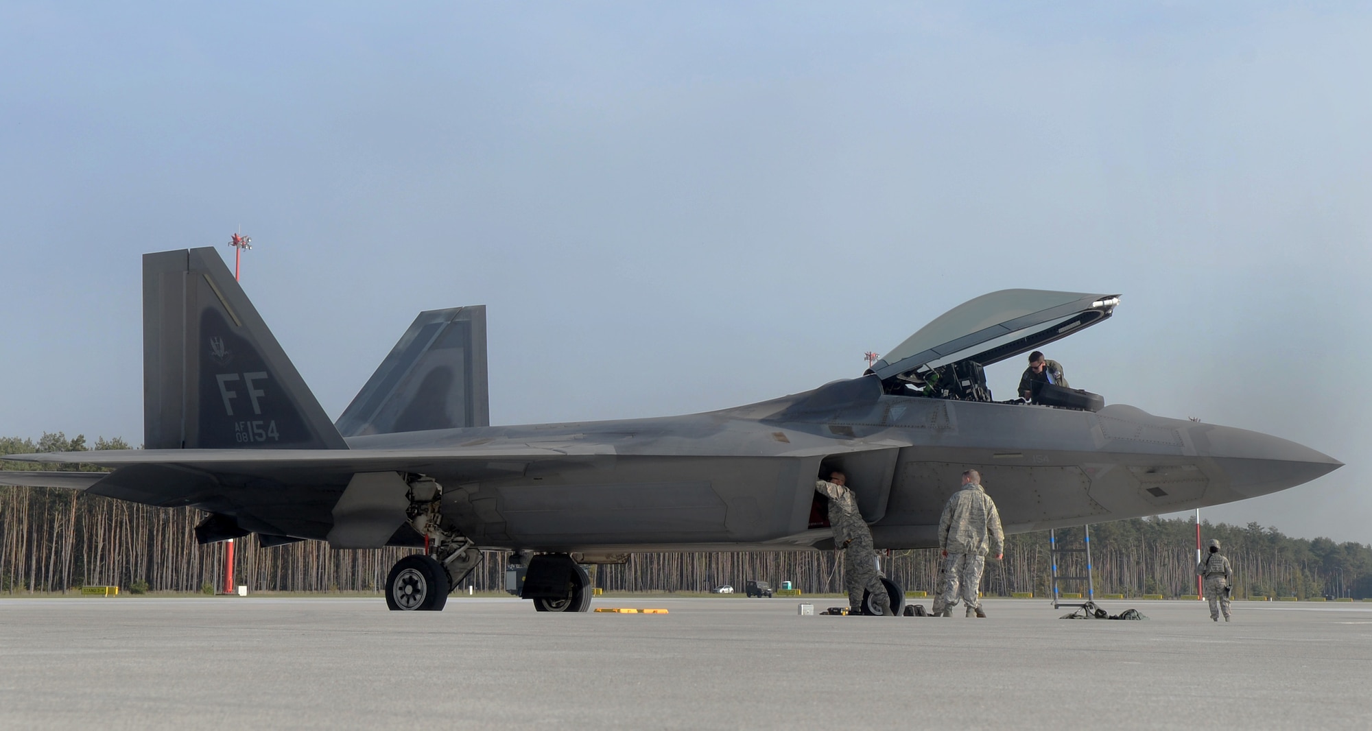 U.S. Air Force maintenance personnel from the 1st Aircraft Maintenance Squadron inspects an F-22 Raptor from the 1st Fighter Wing, Joint Base Langley-Eustis, Va., on the flightline Oct. 17, 2017, at Powidz Air Base, Poland. This F-22 flying training deployment is an example of how the U.S is engaged, postured, and ready with credible force to assure, deter, and defend in an increasingly complex security environment. (U.S. Air Force photo by Senior Airman Tenley Long)
