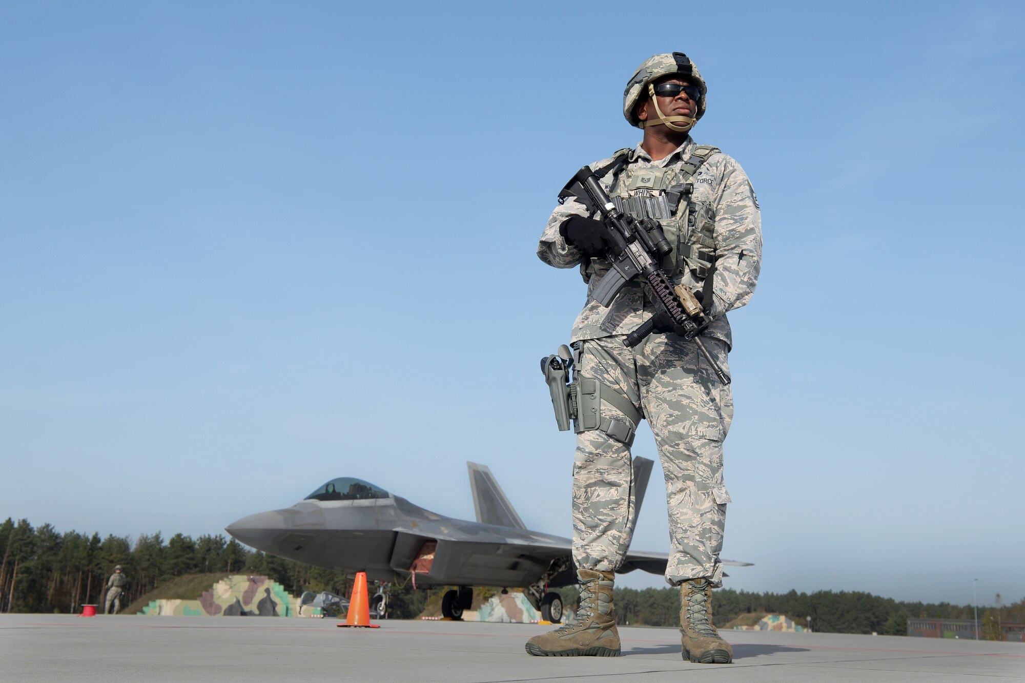 U.S. Air Force Tech. Sgt. Paul White, 633rd Security Forces Squadron flight chief, stands guard of an F-22 Raptor from the 1st Fighter Wing, Joint Base Langley-Eustis, Va., Oct. 17, 2017, at Powidz Air Base, Poland. This forward deployment is an opportunity for the F-22s to maximize training opportunities, demonstrate the U.S. Air Force’s steadfast commitment to NATO allies and deter any actions that destabilize regional security. (U.S. Air Force photo by Senior Airman Tenley Long)