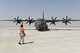 An Airman assigned to the U.S. Air Force 379th Air Expeditionary Wing marshals a Royal Air Force C-130J Hercules to its parking location on the runway at Al Udeid Air Base, Qatar, Oct. 3, 2017.