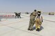 A U.S. Air Force firefighter assigned to the 379th Expeditionary Civil Engineering Squadron assists a Royal Air Force simulated casualty to a staging location while firefighters from the Qatar Emiri Air Force, black uniforms, battle a simulated fire at Al Udeid Air Base, Qatar, Oct. 3, 2017.