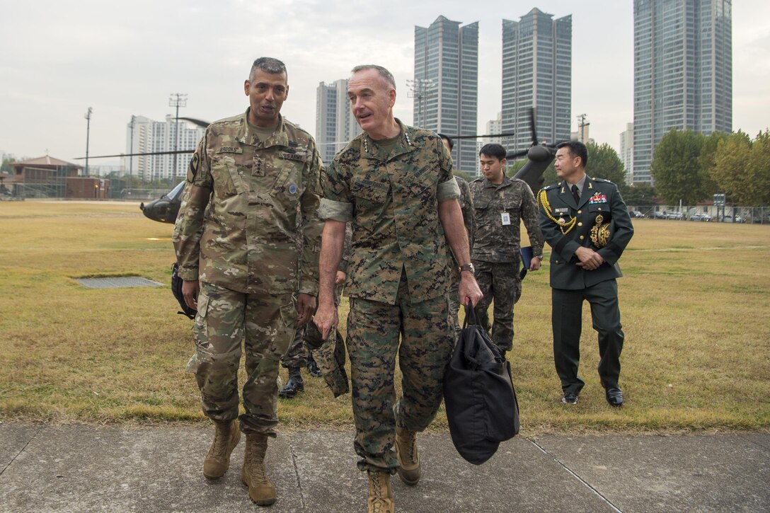 Two military leaders walk together in South Korea.
