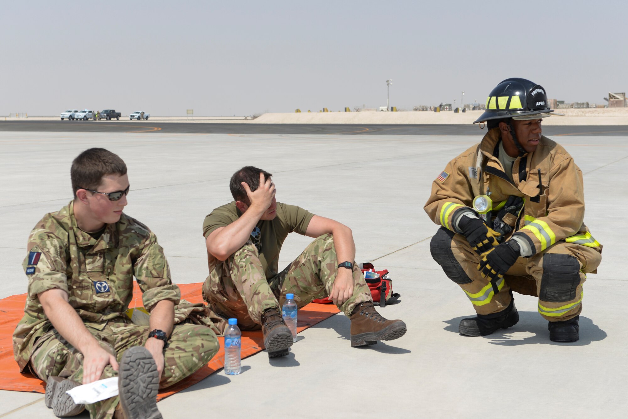 U.S. Air Force Senior Airman William Elliott, firefighter assigned to the 379th Expeditionary Civil Engineering Squadron, right, attends to two simulated casualties played by Royal Air Force airmen, on the runway at Al Udeid Air Base, Qatar, Oct. 3, 2017.