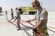 A U.S. Air Force firefighter assigned to the 379th Expeditionary Civil Engineering Squadron, work on putting away hoses following their response to a simulated aircraft accident on the runway at Al Udeid Air Base, Qatar, Oct. 3, 2017.