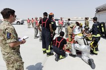 Members of the U.S. Air Force, Royal Air Force, and Qatar Emiri Air Force take part in responding too, and evaluating the response too, a simulated aircraft accident on the runway at Al Udeid Air Base, Qatar, Oct. 3, 2017.