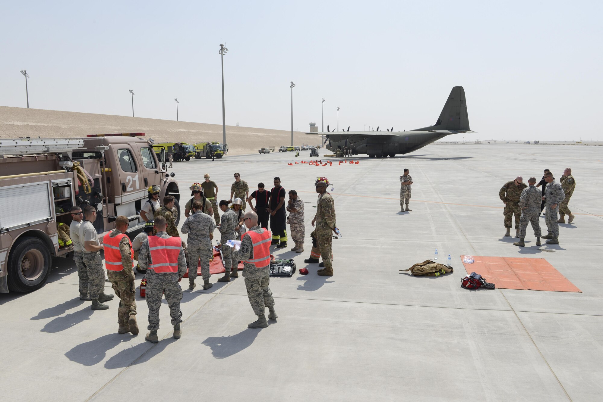 Members of the U.S. Air Force, Royal Air Force, and Qatar Emiri Air Force take part in responding too, and evaluating the response too, a simulated aircraft accident on the runway at Al Udeid Air Base, Qatar, Oct. 3, 2017.
