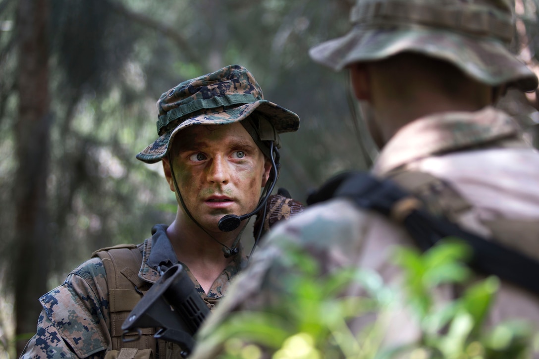 A Marine communicates via hands-free radio during a jungle patrol.