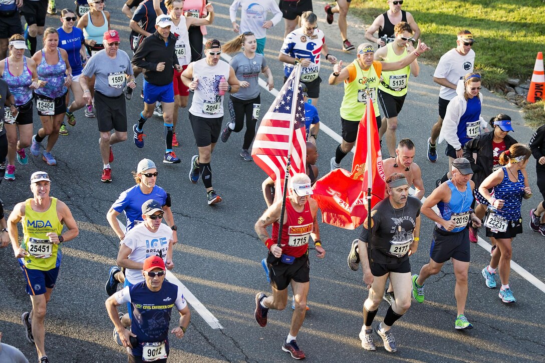 A runner carries the U.S. flag during the Marine Corps Marathon.