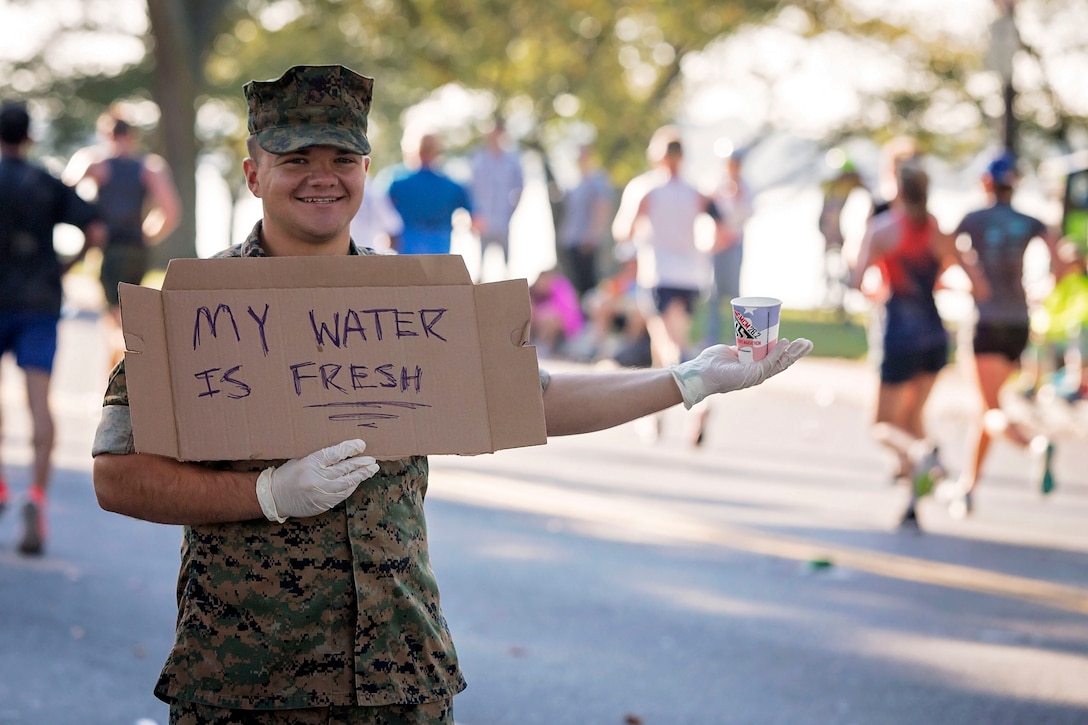 A Marine hands out water during the Marine Corps Marathon.