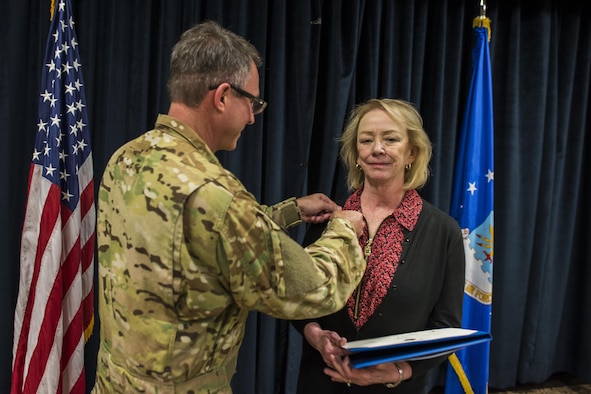 Col. Stewart Hammons, 27th Special Operations Wing commander, presents Janet Day, 27th SOW secretary, with the Outstanding Civilian Career Service Award during Day’s retirement ceremony Sept. 29, 2017, at Cannon Air Force Base, New Mexico. Day served 32 years to the Air Force, 29 of them here at Cannon. (U.S. Air Force photo by Senior Airman Luke Kitterman/Released)