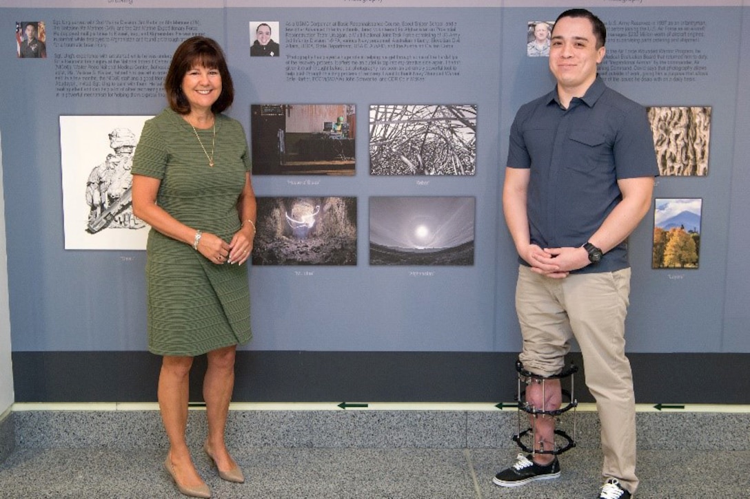 Two people stand next to a display.