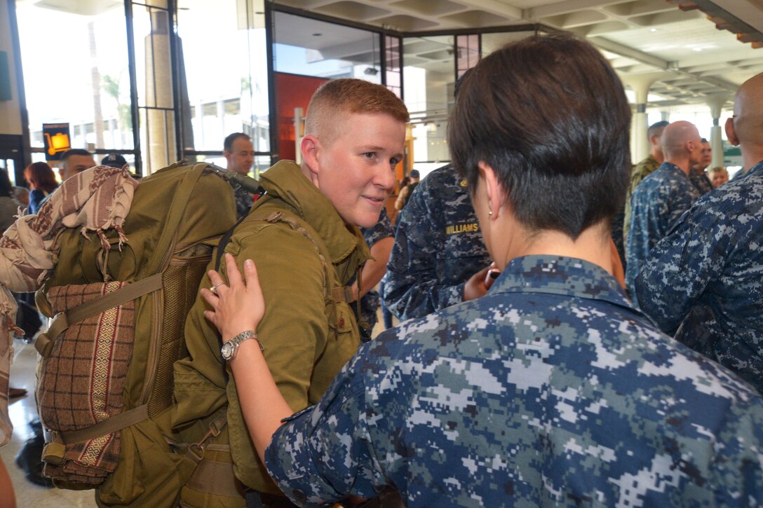 A Navy sailor is welcomed home by coworkers.
