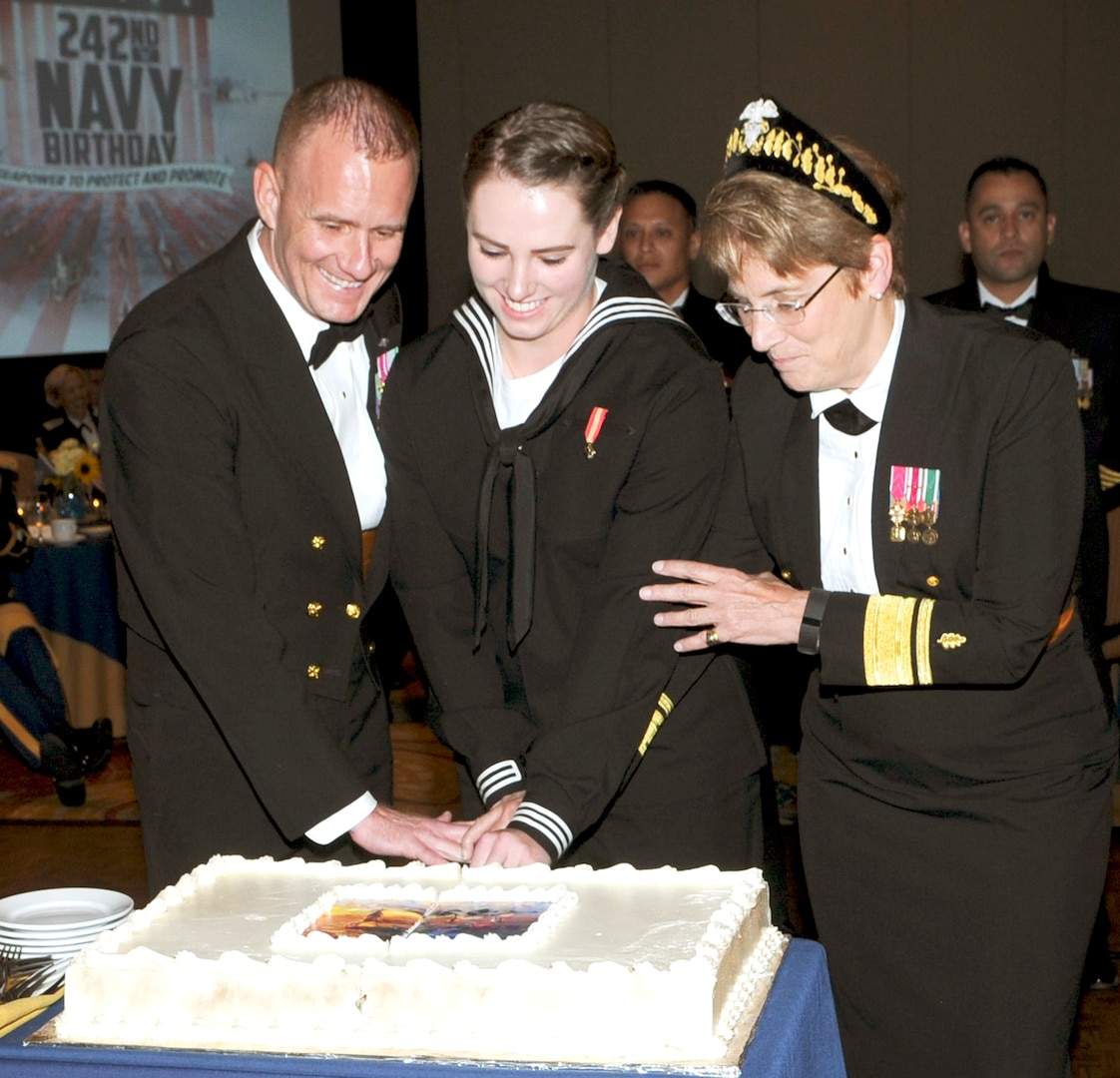Master Chief Petty Officer of the Navy (MCPON) Steven S. Giordano, left, and Rear Adm. Rebecca McCormick-Boyle, right, commander, Navy Medicine Education, Training and Logistics Command (NMETLC), cut the ceremonial cake with Seaman Recruit Harley Valdez, the youngest Sailor in attendance, at the Texas Regional Navy Birthday Ball Oct. 20 in San Antonio, Texas. More than a dozen sea service commands in the San Antonio area gather annually to celebrate the Navy birthday in a joint celebration.