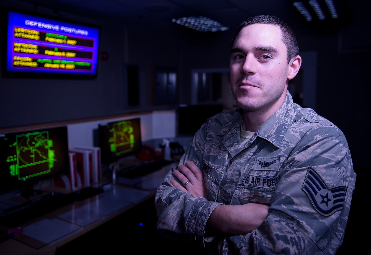 Staff Sgt. Kennett stands in front of displays in the Solid State Phased Array Radar System at Clear Air Force Station, Alaska.