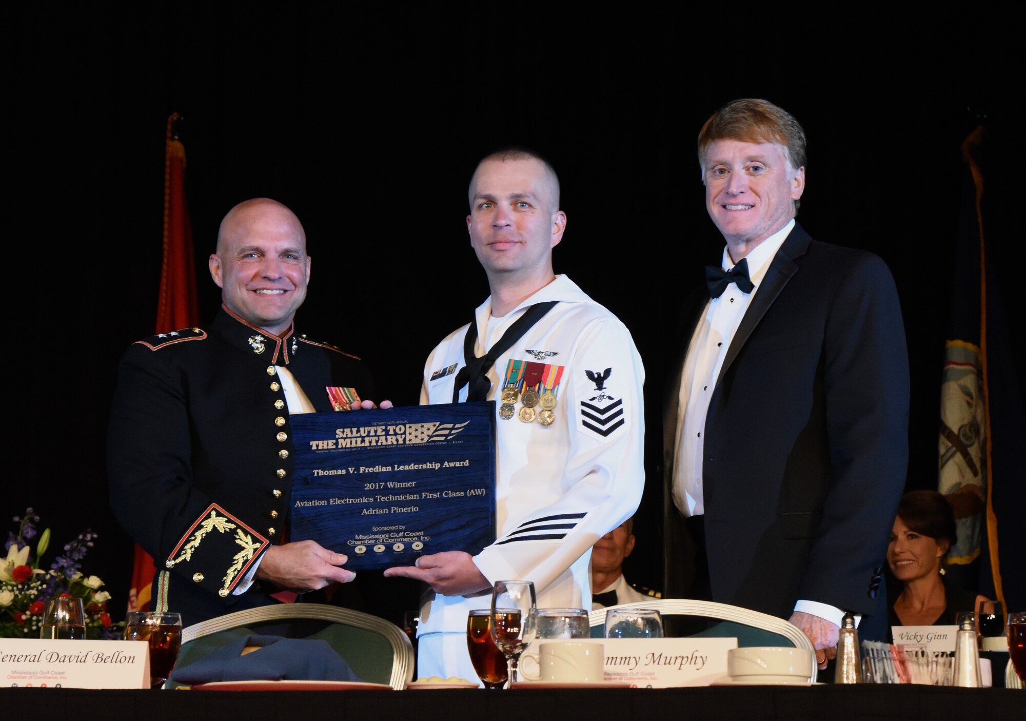 U.S. Navy Aviation Electronics Technician 1st Class Adrian Piñeiro, Center for Naval Aviation Technical Training Unit Keesler instructor, receives the Thomas V. Fredian Community Leadership Award  from members of the head table during the 39th Annual Salute to the Military at the Mississippi Coast Convention Center, Oct. 24, 2017, Biloxi, Mississippi. Piñeiro is an instructor at the calibration school at CNATTU Keesler and is responsible for providing technical and administrative support for Navy students. He personally delivered over 1,400 hours of college level curriculum to joint and international students. He also serves as the command’s community service coordinator, organizing all aspects of community service for 68 staff and more than 700 students. (U.S. Air Force photo by Kemberly Groue)
