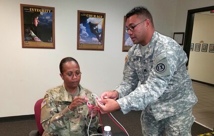 (Standing) Staff Sgt. John Taitin, an instructor with the 4960th Multifunctional Training Brigade, 9th Mission Support Command, teaches Master Sgt. Barbara Parker knot tying in his class at the 80th Training Command 2017 Instructor of the Year competition at Fort Knox, Kentucky, Oct. 21, 2017.