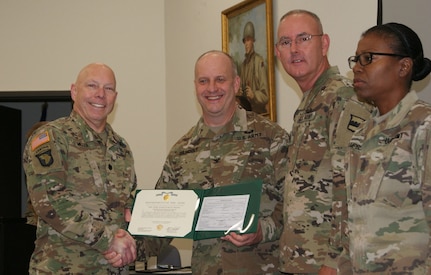 (Left to right) Lt. Col. Kevin Miller, Col. Jay Gilhooly, Command Sgt. Maj. Jeffrey Darlington, and Command Sgt. Maj. Sharon Campbell pose for photographs as Miller receives the 80th Training Command 2017 Instructor of the Year officer award at the completion of the two-day competition at Fort Knox, Kentucky, Oct. 22, 2017.  Miller serves as an instructor for the 100th Training Division-Leader Development.