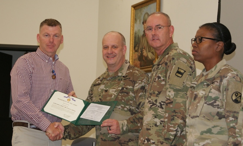 (Left to right) Mr. Troy Winters, Col. Jay Gilhooly, Command Sgt. Maj. Jeffrey Darlington, and Command Sgt. Maj. Sharon Campbell pose for photographs as Winters receives the 80th Training Command 2017 Instructor of the Year civilian award at the completion of the two-day competition at Fort Knox, Kentucky, Oct. 22, 2017.  Winters serves as an instructor for the 83rd Army Reserve Readiness Training Center, 100th Training Division.