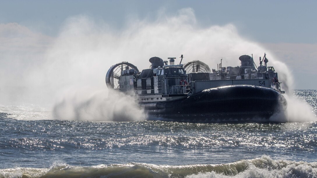 An air-cushioned landing craft creates a wake while operating in the ocean.