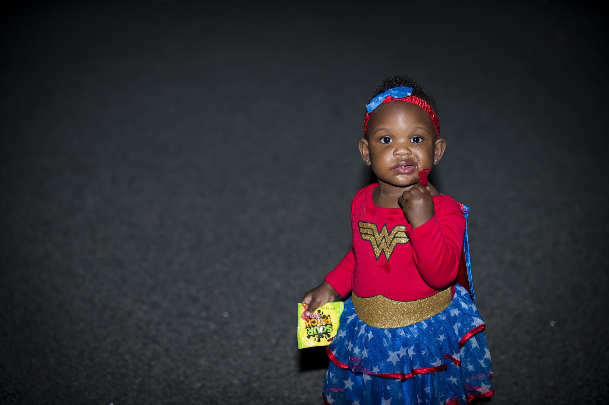Kinsley Young, daughter of Staff Sgt. Ceaira Young, 23d Wing, eats candy at the Trunk or Treat event Oct. 20, 2017, at Moody Air Force Base, Ga. More than 3,500 Airmen and their families participated in the annual Trunk or Treat event hosted by the 23d Force Support Squadron Youth Programs. (U.S. Air Force photo by Andrea Jenkins)