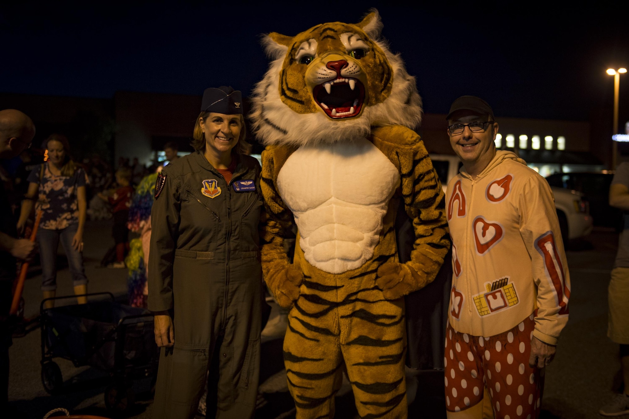 Col. Jennifer Short, 23d Wing commander, and Chief Master Sgt. Jarrod Sebastian, 23d WG command chief, pose for a photo with a tiger during the Trunk or Treat event Oct. 20, 2017, at Moody Air Force Base, Ga. More than 3,500 Airmen and their families participated in the annual Trunk or Treat event hosted by the 23d Force Support Squadron Youth Programs. (U.S. Air Force photo by Andrea Jenkins)
