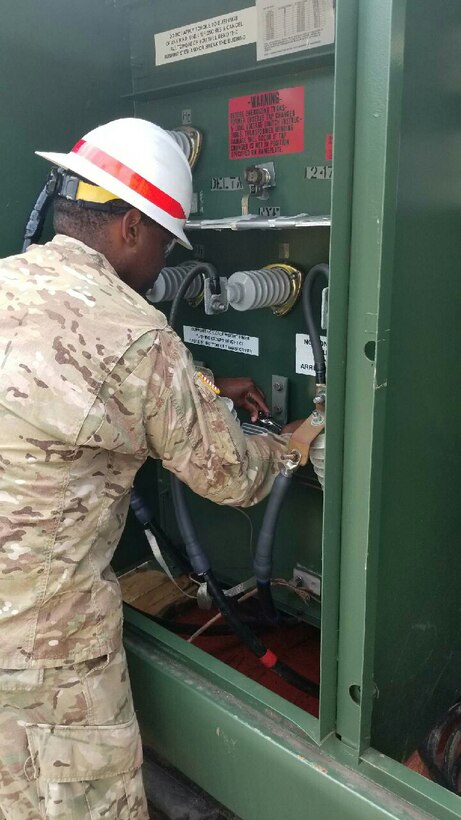 Sgt. Edwards, of the 249th Engineer Battalion, replaces and tests a surge arrester on the 1.5 Mega Volt Ampere transformer at Baldorioty de Castro Pump Station in Puerto Rico.