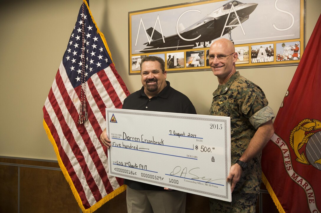 U.S. Marine Corps Col. David Suggs (right), the commanding officer of Marine Corps Air Station Yuma, Ariz., recognizes Darren Ercanbrack (left), MCAS Yuma’s Air Traffic Control (ATC) supervisor, as the MCAS Yuma Employee of the 3rd Quarter, Aug. 7, 2017. (U.S. Marine Corps photo taken by Pfc. Sabrina CandiaFlores)