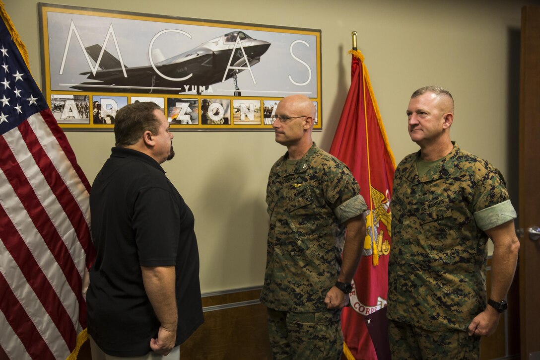 U.S. Marine Corps Col. David Suggs (center) , the commanding officer of Marine Corps Air Station Yuma, Ariz., and SgtMaj. David Leikwold (right), the sergeant major of MCAS Yuma, stand at attention as they recognize Darren Ercanbrack (left), MCAS Yuma’s Air Traffic Control (ATC) supervisor, as the MCAS Yuma Employee of the 3rd Quarter, Aug. 7, 2017. (U.S. Marine Corps photo taken by Lance Cpl. Isaac D. Martinez)