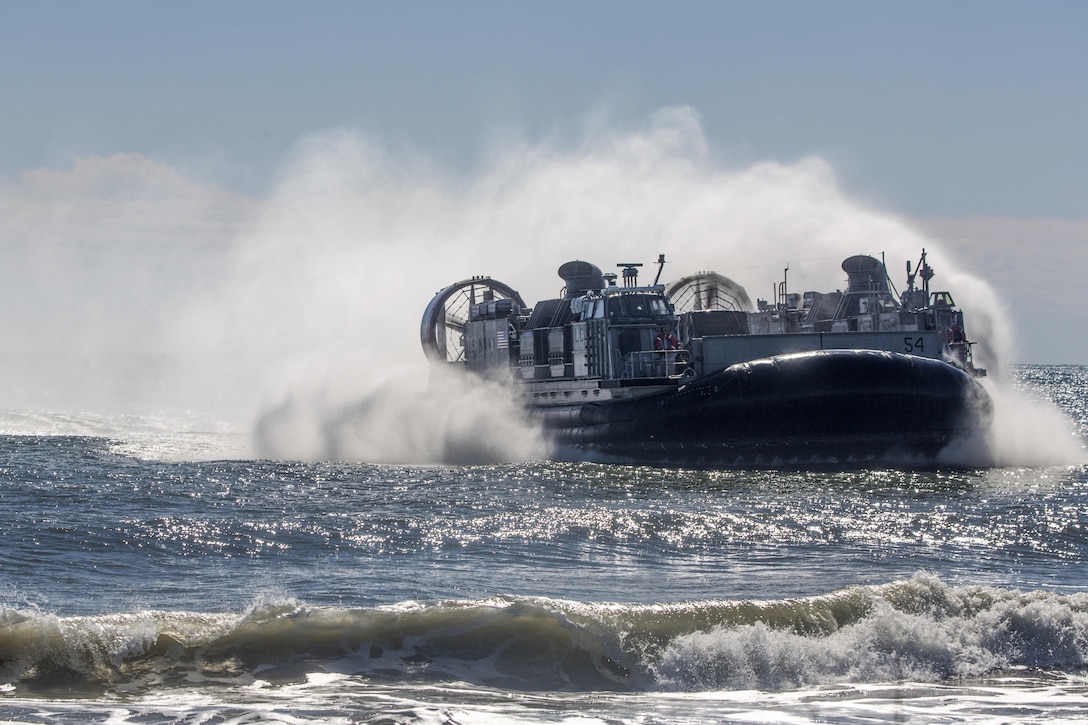 An air-cushioned landing craft creates a wake while operating in the ocean.