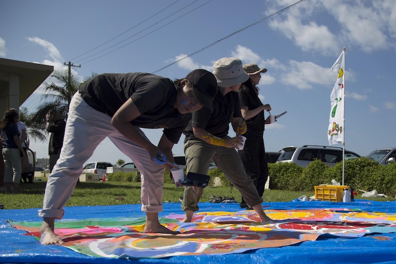 KADENA AIR BASE, OKINAWA, Japan – The Coupii Fashion Art Group  add finishing touches to a banner at the community paint project Oct. 26 at Kadena Marina on Okinawa, Japan.