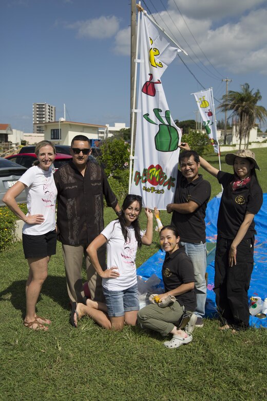 KADENA AIR BASE, OKINAWA, Japan – Members of the Coupii Fashion Art Group, the North Island Officer Spouses Club and Sgt. Maj. Mario Marquez pose with the CFAG flag during a community art project Oct. 26 at the Kadena Marina on Okinawa, Japan.