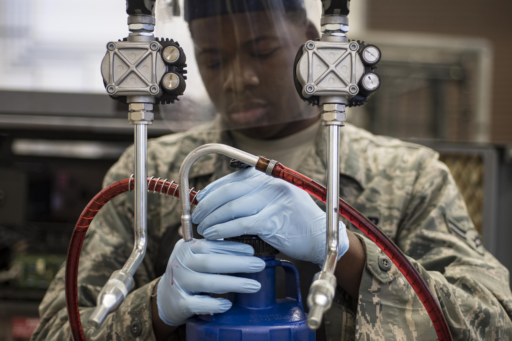 U.S. Air Force Airman 1st Class Harold Jordan, 86th Maintenance Squadron Aerospace Ground Equipment apprentice, fills a mobile hydraulic fluid container at the AGE facility on Ramstein Air Base, Germany, Oct. 25, 2017. The AGE flight works on a variety of equipment that directly supports Airmen on the flightline. (U.S. Air Force photo by Senior Airman Devin Boyer)