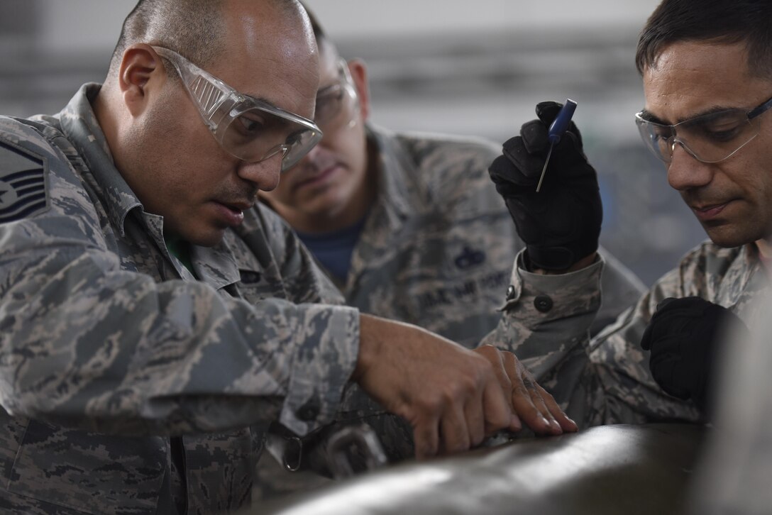 Master Sgt. Ruben Ayala, left, 52nd Contracting Squadron contracting officer, and Master Sgt. Jason Riter, 52nd Maintenance Group first sergeant, work together to build an inert bomb while participating in the 52nd Maintenance Squadron Ammo Rally at Spangdahlem Air Base, Germany, Oct. 20, 2017. Airman from various career fields competed for best time on building an inert bomb. (U.S. Air Force photo by Senior Airman Preston Cherry)