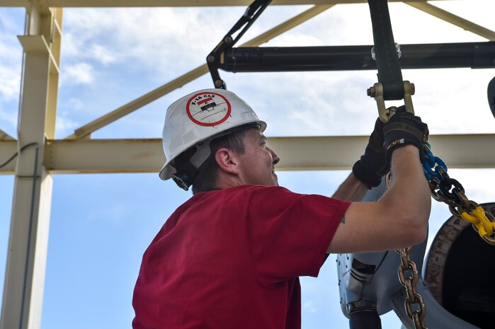 Greg Passmore, 437th Aerial Port Squadron material manager, chains down a helicopter training device for weight measurement at Joint Base Charleston, S.C., Oct. 19, 2017.