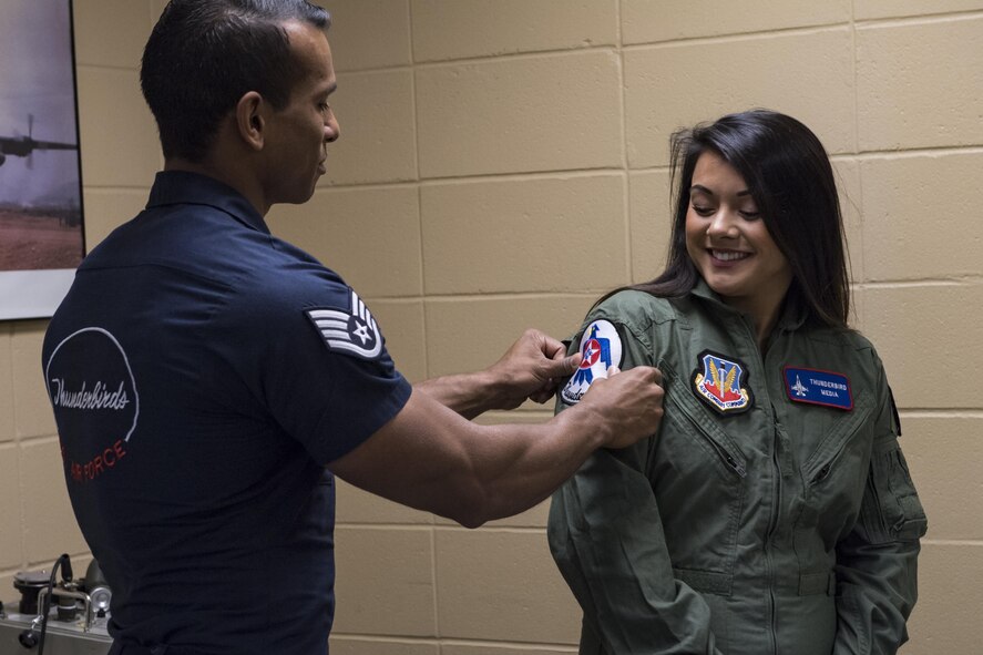 Staff Sgt. Kyle Boddie, U.S. Air Force Thunderbirds aircrew flight equipment technician, puts a Thunderbird patch on Noelani Mathews, multimedia journalist her media flight in an F-16D Fighting Falcon, Oct. 27, 2017, at Moody Air Force Base, Ga. The Thunderbirds, based out of Nellis Air Force Base, Nev., are the Air Force’s premier aerial demonstration team, performing at air shows and special events worldwide. (U.S. Air Force photo by Senior Airman Janiqua P. Robinson)