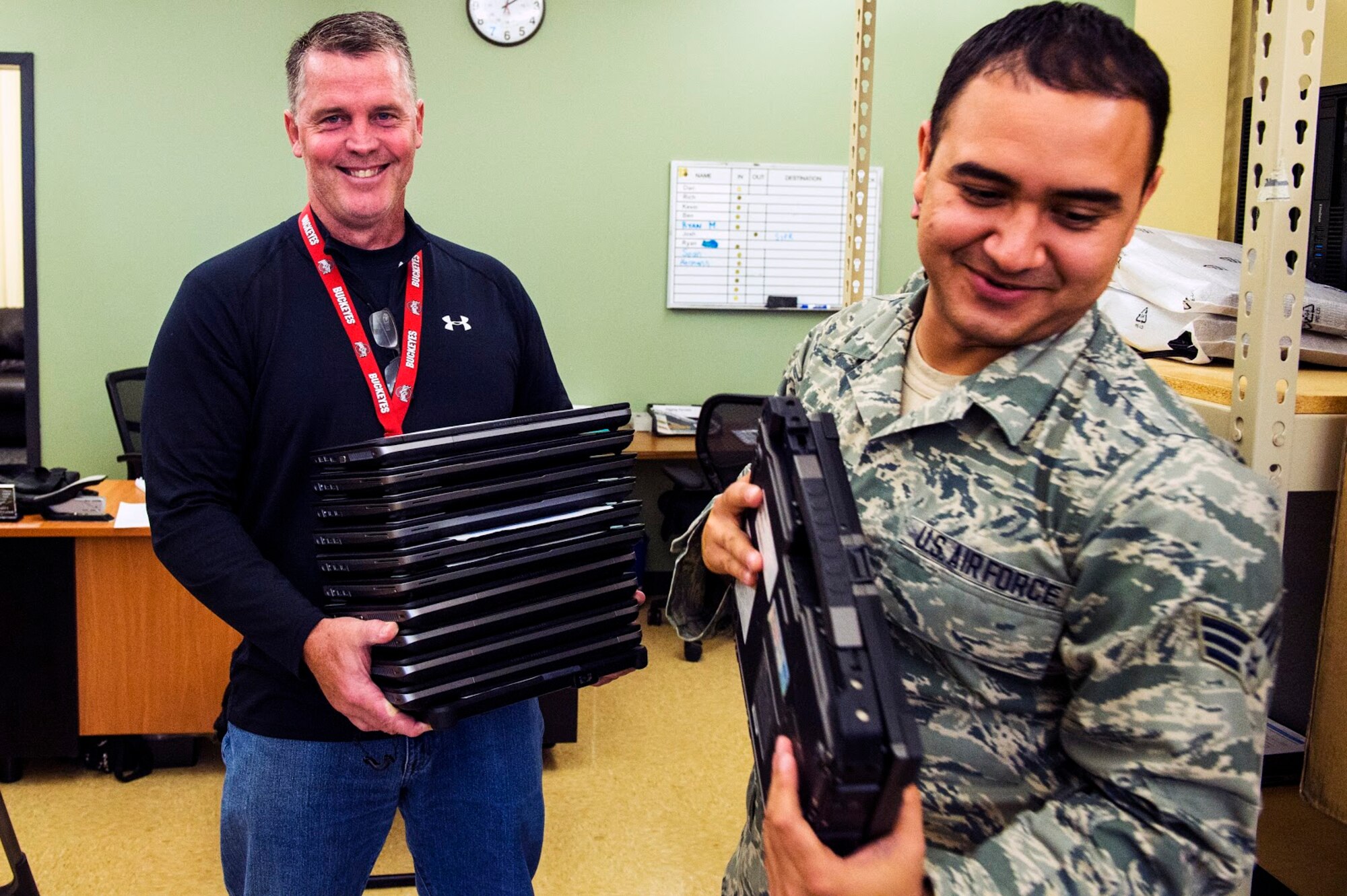 Richard Percival, 434 Communications Squadron customer service representative, and Herman Vasquez, 434 CS network infrastructure technician, carry laptops scheduled to be upgraded to a new operating system at Grissom Air Reserve Base, Oct. 25, 2017. Over 1400 Grissom computers required upgrades from Windows 7 to Windows 10 before the end of 2017. (U.S. Air Force photo/ Senior Airman Harrison Withrow)