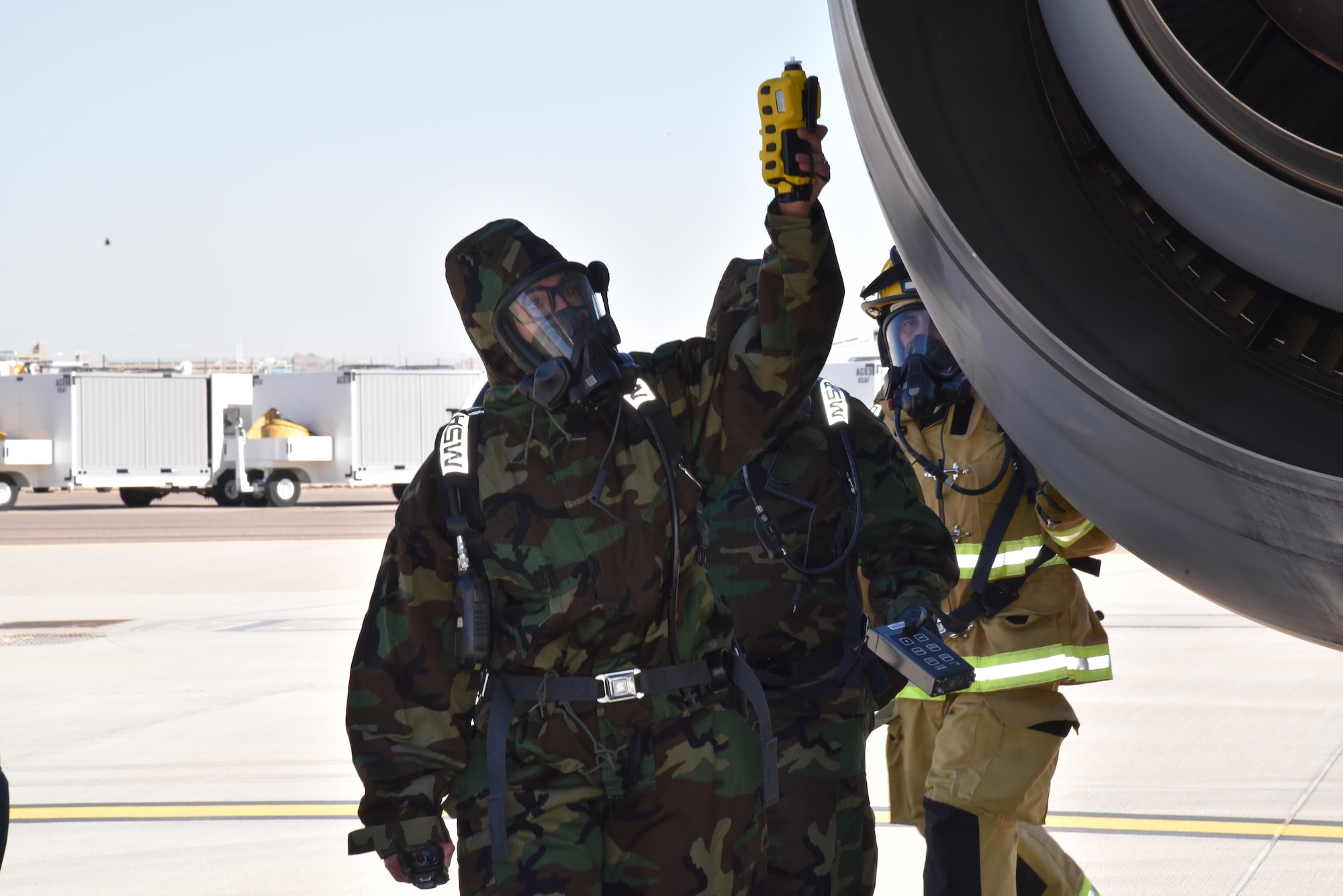 Hazardous Material, also known as HAZMAT, personnel circulate the fictitiously crashed aircraft to determine if it emits flammable elements here during the 2017 Triennial Exercise, 26. Oct. 2017. For the first time in many years, the exercise was conducted on the Air Guard side of the ramp. (U.S. Air Force photo by 2nd Lt. Tinashe Machona)