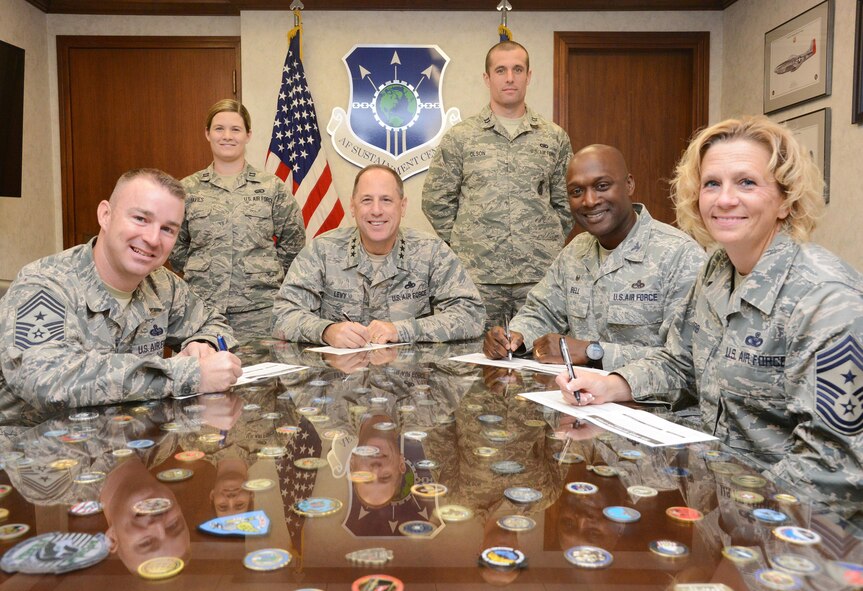 Captains Samantha Davies, with the 72nd Force Support Squadron, and Michael Olson, with the 72nd Security Forces Squadron, Tinker's Combined Federal Campain coordinators, watch as Air Force Sustainment Center Command Chief Master Sgt. Gary Sharp, AFSC Commander Lt. Gen. Lee K. Levy II, 72nd Air Base Wing Commander Col. Kenyon Bell and 72nd ABW Command Chief Master Sgt. Melissa Erb sign their pledge cards for the 2017 Combined Federal Campaign.